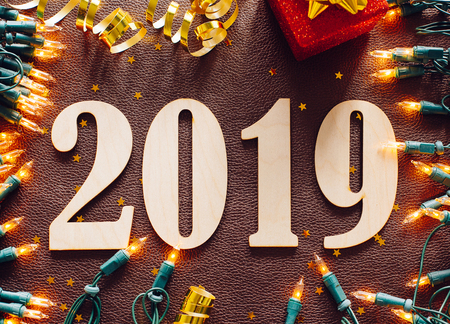 Christmas and New Year composition. 2019 simbols and garland on brown leather background. Flat lay, top viewの写真素材