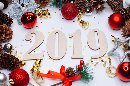 Christmas and New Year composition. 2019 simbols and fir branches with cones and christmas balls in silver and red colours on white background. Flat lay, top view, copy space for textの写真素材