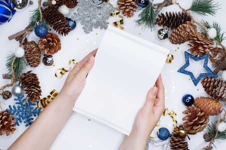 Woman hands with notepad on Christmas and New Year background. To do list or list of promises, place for your textの写真素材