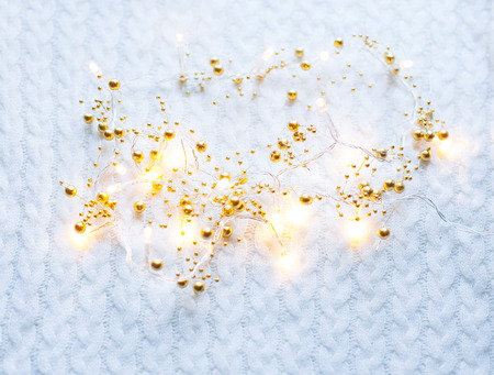 Christmas and New Year decorations lights on white knitted background.の写真素材