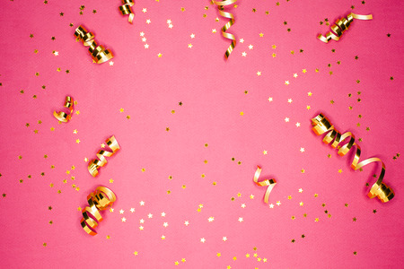 Golden decorations and sparkles on bright  pink backgroundの写真素材