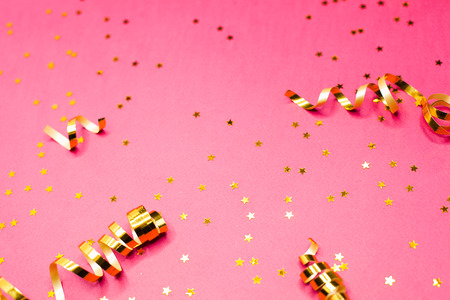 Golden decorations and sparkles on bright  pink background