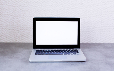Front view of desktop with blank laptop on wall background. Mock up Imageの写真素材