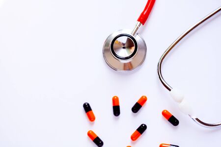 stethoscope for doctor checkup with pills on health medical laboratory table backgroundの写真素材