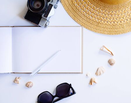 Flat lay design of travel concept with camera, notebook, hat, shells on white backgroundの写真素材