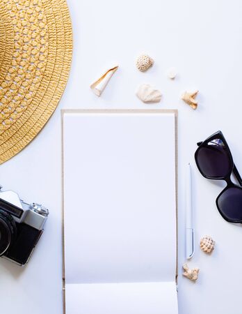 Flat lay design of travel concept with camera, notebook, hat, shells on white backgroundの写真素材