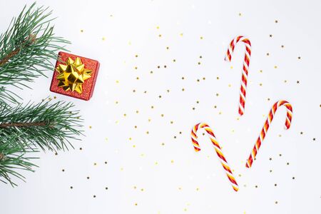 Christmas composition. Fir tree branch, red gift box, candy canes on white  background. Christmas, winter, new year concept. Flat lay, top viewの写真素材