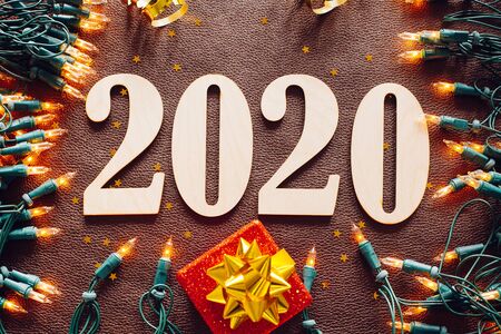 Christmas and New Year composition. 2020 simbols and garland on brown leather background. Flat lay, top viewの写真素材