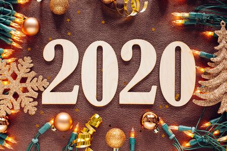 Christmas and New Year composition. 2020 simbols and garland on brown leather background. Flat lay, top viewの写真素材