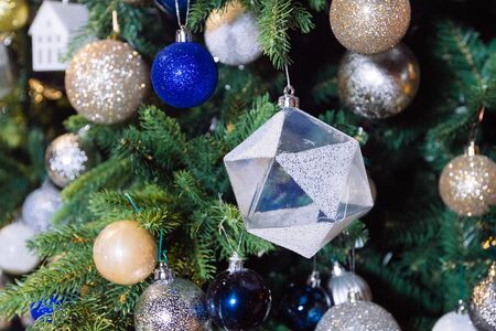 Decorated Christmas tree with house toy on blurred, sparkling and fairy backgroundの写真素材