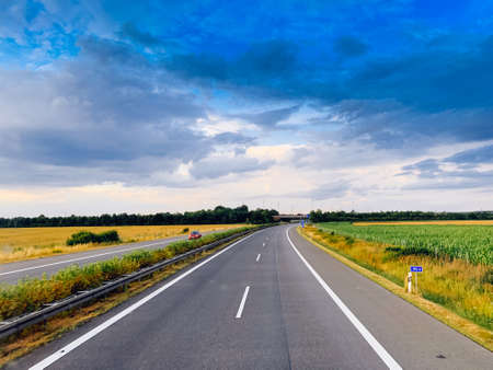 Asphalt road and beautiful nature landscape at sunsetの写真素材