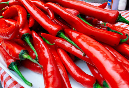 Beautiful red peppers or chilies on red plaid tablecloth background. Fresh Red hot chili pepperの写真素材