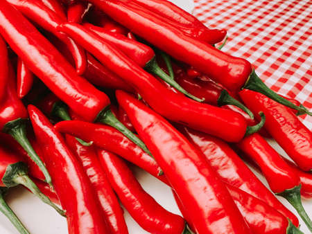 Beautiful red peppers or chilies on red plaid tablecloth background. Fresh Red hot chili pepperの写真素材