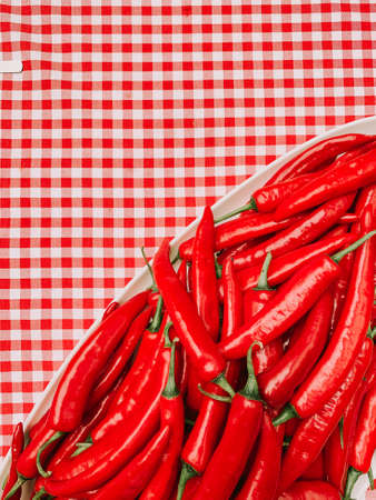 Beautiful red peppers or chilies on red plaid tablecloth background. Fresh Red hot chili pepperの写真素材