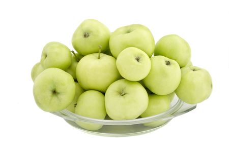 Green apples in a glass plate on a white backgroundの写真素材