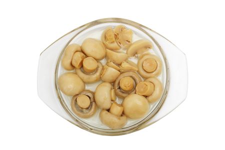 The tinned champignons in a plate are isolated on a white backgroundの写真素材