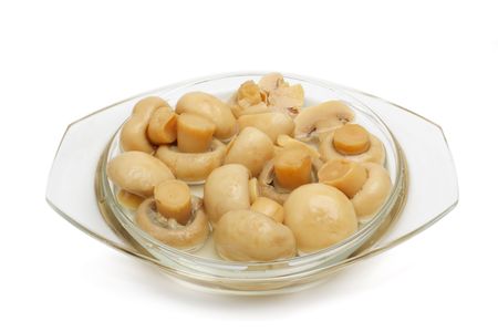 The tinned champignons in a plate are isolated on a white backgroundの写真素材