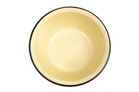 The yellow enameled plate is isolated on a white backgroundの写真素材