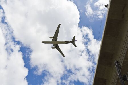 Two engines aircraft prepares for landing over skytrain railroad  airport link train , Bangkok,...