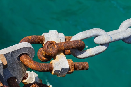 Ship mooring by galvanized ship chain and shackle, with sea water in backgroundの写真素材