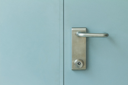 Close up of stainless steel door lock on industrial steel doorの写真素材