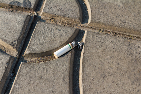 Cigarette butt on concrete walkway result from indiscipline personの写真素材