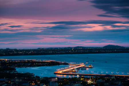 CHONBURI, THAILAND - 14 AUGUST 2015 - Light trails on the curved road beside the sea and twilight sky over Chonburi city.のeditorial素材