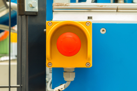 Close up of emergency stop button switch, an electrical device for safety, installed on the machine