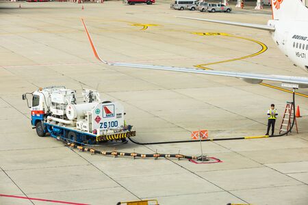 BANGKOK, THAILAND - 12 SEPTEMBER 2015 - Refuel truck with pressure apparatus and hose is used for underwing fueling also called single-point refueling or pressure refueling to Boeing 737 aircraft at Don Mueang International Airport, Bangkok, Thailand.のeditorial素材
