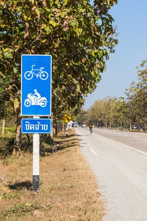 Bike lane signpost for bicycle and motorcycle in Thailand, word on the bottom signpost means keep leftの写真素材