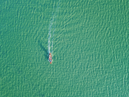Aerial view from drone of fishing boat moving in the sea, minimalist photography