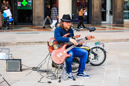 MILAN, ITALY - 14 APRIL 2018 - Unidentified street performer plays his guitars in public area in...