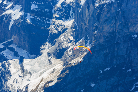 GRINDELWALD, SWITZERLAND - 24 APRIL 2018 - Unidentified couple glide with paramotor from Grindelwald First into the air of Jungfrau Region valleyのeditorial素材