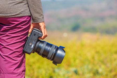 Photographer holds her DSLR camera in her right hand