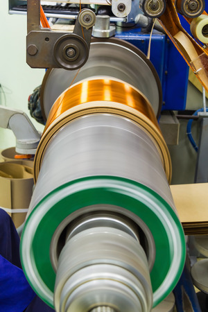 Round enamelled wire being wound to form the transformer ht (high tension) coil on the winding machine in manufacturingの写真素材