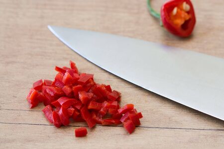 Selective focus image of chopped green pepper and a knife on a wooden board.の写真素材