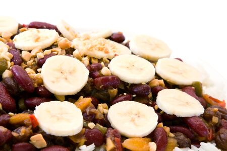 Traditional South African vegetarian curry made from kidney beans and dried fruits, served with rice, bananas and peanuts as cut out image.の写真素材