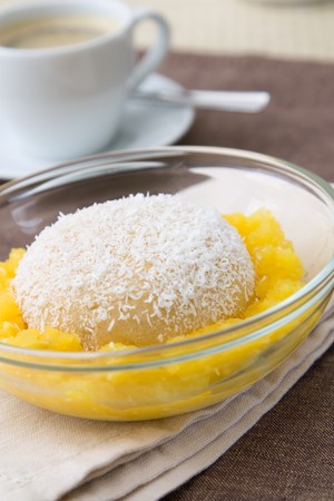 Selective focus image of a semolina pudding with mango and coco flakes.の写真素材