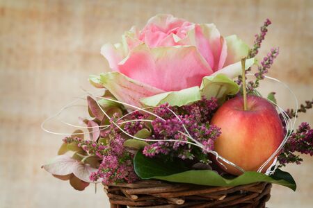 Decorative autum flower arrangement with rose and apple.の写真素材