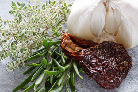 Mediterranean ingredients like rosemary, thyme, dried tomatoes and garlic.の写真素材
