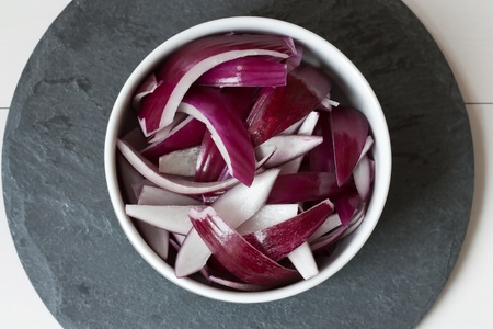 Selective focus image of chopped red onions in a white bowl.の写真素材