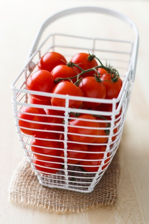 White basked with fresh tomatoes.の写真素材