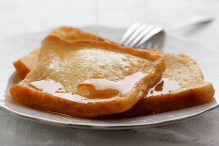 French Toast served on a plate with maple syrup.