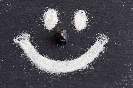 Happy face which is made from sand on a stone background.の写真素材