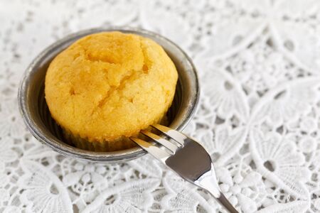 Lemon muffin with a pasty fork served on a doily.の写真素材