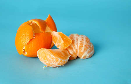 Juicy peeled orange and peel on blue backgroundの写真素材