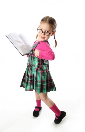 Cute preschool girl wearing eyeglasses holding a bookの写真素材