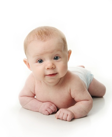 Happy young baby lying on tummy isolated on a white background.の写真素材