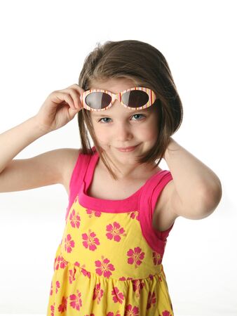 Portrait of a cute girl pulling up sunglasses on head, isolated on white in studio.の写真素材