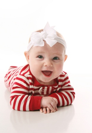 Cute baby wearing Christmas pajamas lying on tummy, isolated on whiteの写真素材
